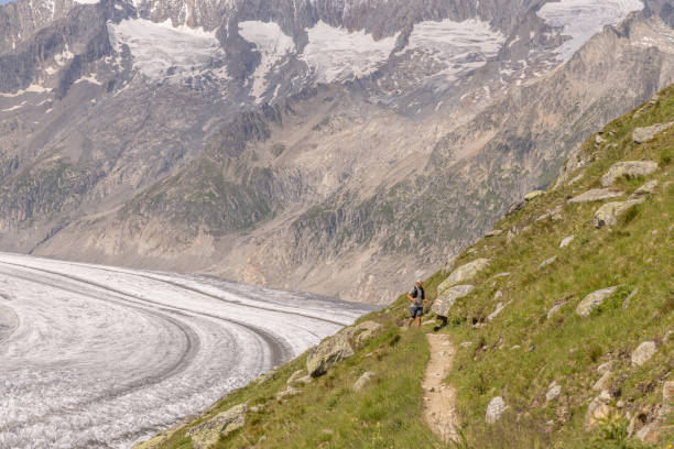 istock Distant trail runner ascends alpine path in Swiss mountain landscape 1729019459