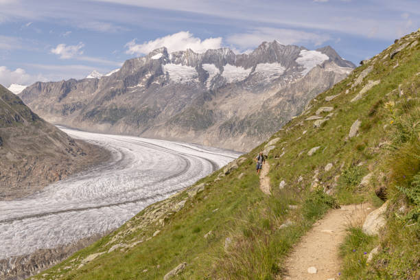 istock Distant trail runner ascends alpine path in Swiss mountain landscape 1729019461