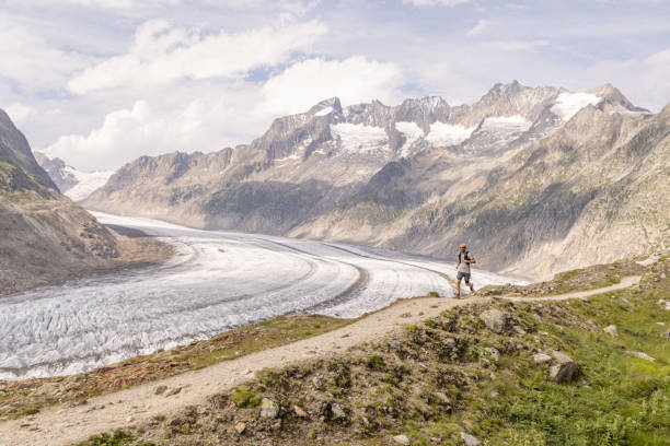 istock Distant trail runner ascends alpine path in Swiss mountain landscape 1729020507