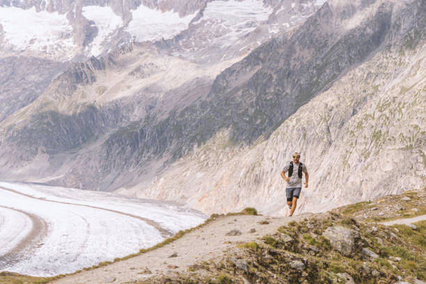 istock Trail runner ascends alpine path in Swiss mountain landscape 1729022599