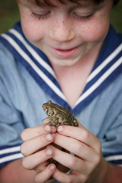 Cute Happy Young Boy in Sailor Suit Holding Frog