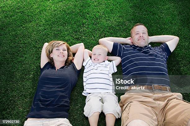 Happy Family Lying In The Grass Stock Photo - Download Image Now - Family, Polo Shirt, Child