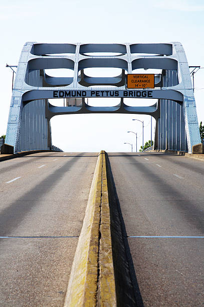 Center street view of Alabama Edmund Pettus Bridge "The Edmund Winston Pettus Bridge is located just east of Selma, Alabama on US 80. Dr. Martin Luther King Jr. led a march across this bridge on the Selma to Montgomery march for voting rights in 1965." black civil rights stock pictures, royalty-free photos & images