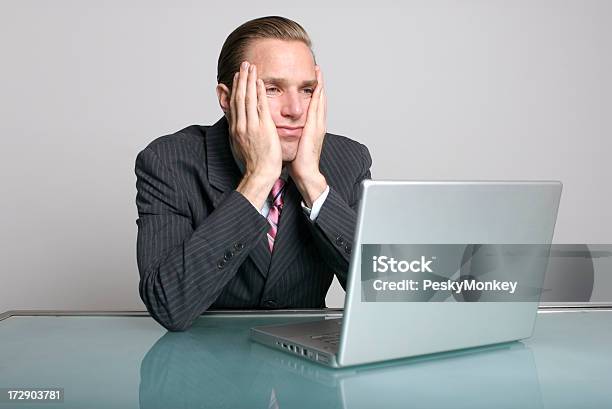 Businessman Looks Bored In Front Of Laptop Computer At Desk Stock Photo - Download Image Now