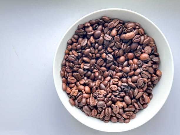 istock Isolated white bowl cup filled with the dark roasted coffee been. 1729038922