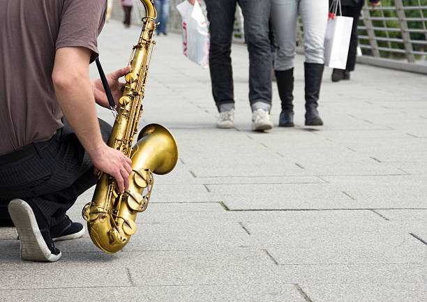 Street performer musician playing saxophone music to London pedestrians stock photo