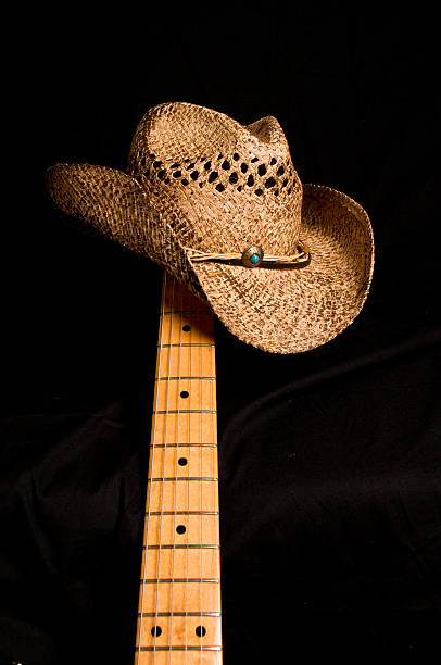 ковбойская шляпа и гитара - low key audio стоковые фото и изображения