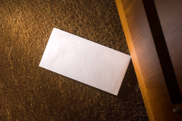 letter on the doormat a blank envelope has landed on the doormat .moodily lit .see also suspicious message stock pictures, royalty-free photos & images