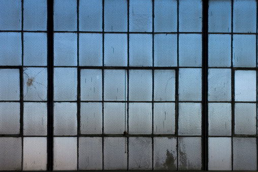 Dirty grungy old windows in a factory.