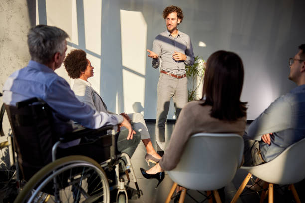 istock Male coach talking on a group therapy in the office. 1729063062