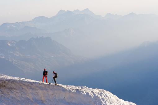 Two people standing on top of an icy mountain top