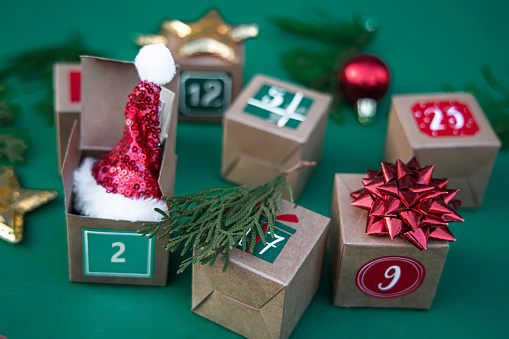 Crafted Advent calendar: paper cubes featuring numbers set against a lively green background. Embrace the Christmas tradition