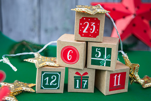 Crafted Advent calendar: paper cubes with numbers on a bright green backdrop. A Christmas tradition and holiday ornament