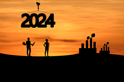 Concept Happy new year Silhouette of engineer and construction to create lifting crane 2024 and factory on sunrise background.