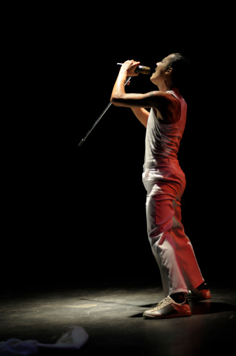 A young man is singing on stage.