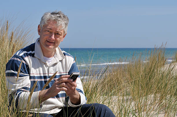 e メールのチェック、携帯電話 - mobility e mail vacations beach ストックフォトと画像