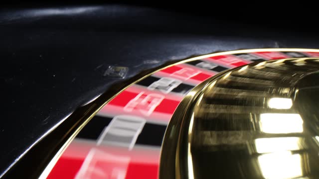 White ball rolls on black and gold roulette wheel