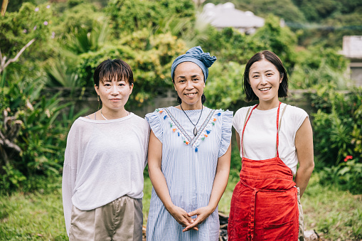 Portrait of a smiling Japanese women, their happiness blending harmoniously with the natural greenery around them.