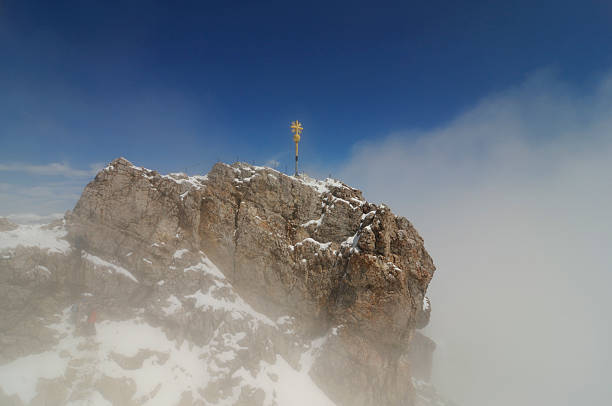 Frozen mountain summit cross on top of a mountain in the European Alps