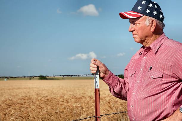 rolnictwo: american rolnik lub ranczer przez ogrodzenie i pszenicy pole - flag of oklahoma zdjęcia i obrazy z banku zdjęć