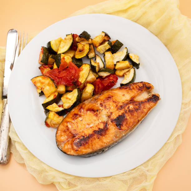 istock Fried salmon with vegetables on white plate 1729134461