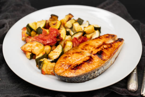 istock Fried salmon with vegetables on white plate 1729134462