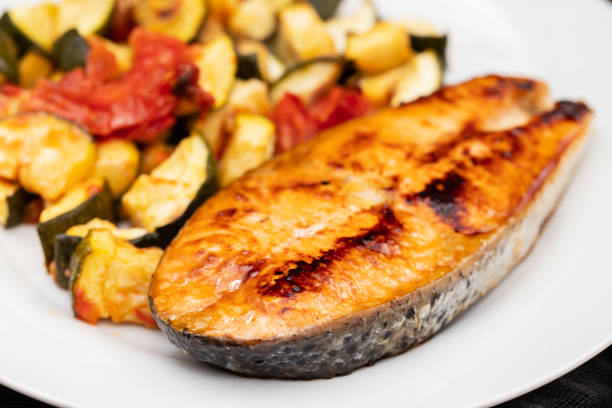 istock Fried salmon with vegetables on white plate 1729134474