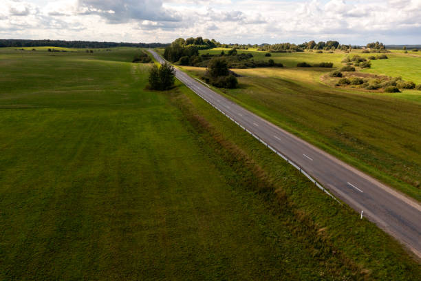 istock Drone photography or rural road going through meadows and forest 1729140290