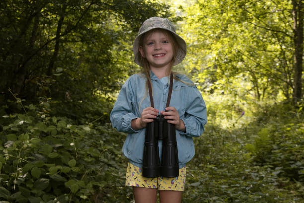 istock Cute little girl exploring nature looking through binoculars. Child playing outdoors. Kids travel, adventure and bird watching concept. 1729142533