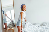 Young woman making her bed in the morning, Morning routine.