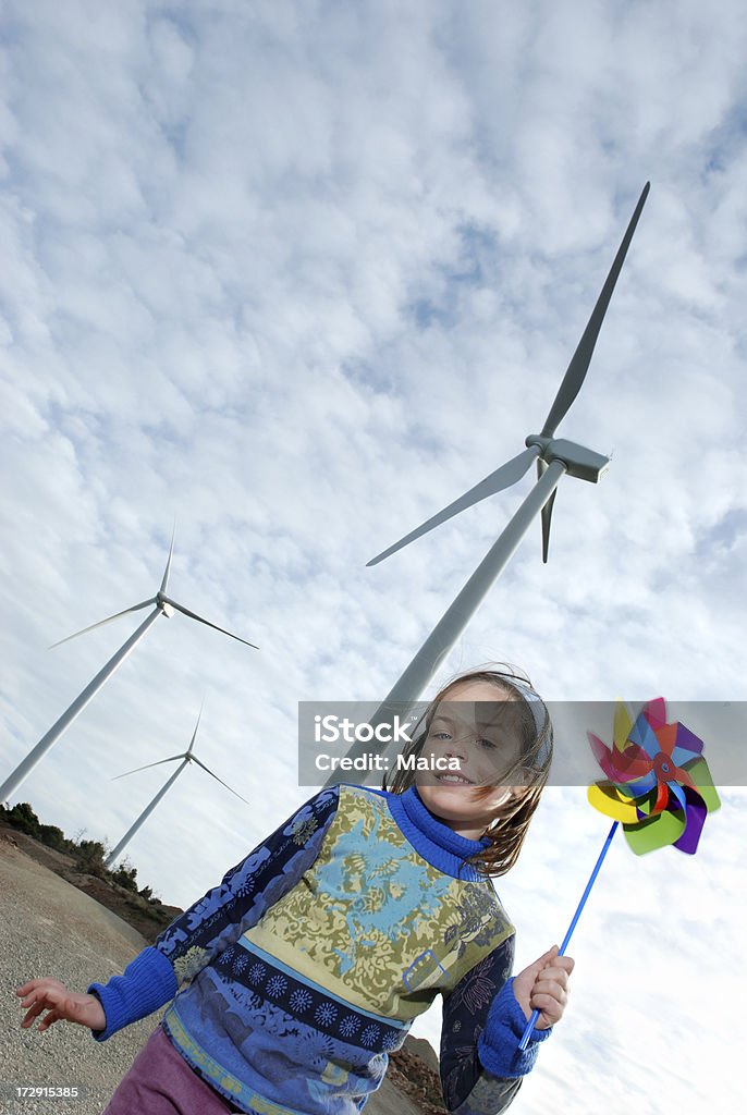 Alternative Energy Girl showing a pinwheel. Wind turbine field behind.Many more of this model and theme at: Lightbox: Child Stock Photo