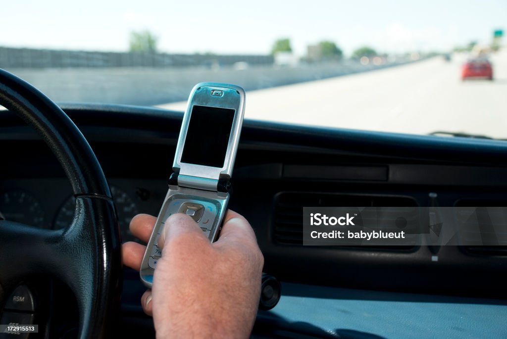 unsafe driving Man Texting on a cel phone while driving on the freeway Bluetooth Stock Photo