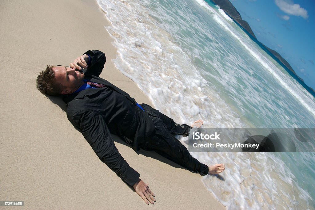 Joven empresario reclinables en la playa hablar con teléfono móvil - Foto de stock de Conmoción libre de derechos