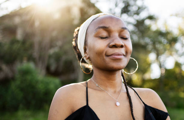 istock Young woman smiling while standing with her eyes closed outdoors in summer 1729167214