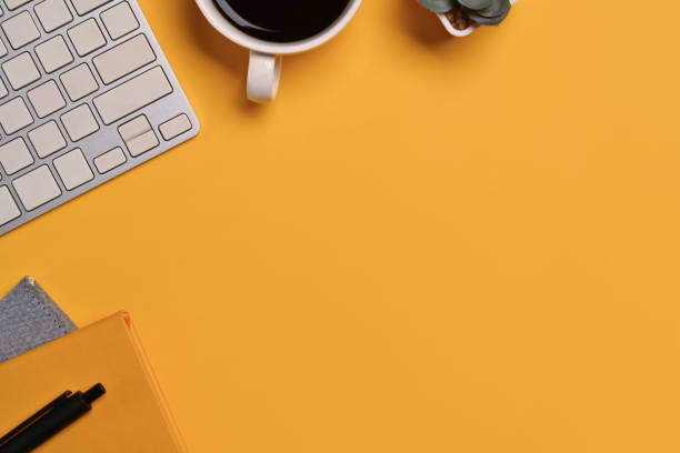 istock A coffee cup, keyboard and notebook on yellow background. Space for text advertising text message 1729167754
