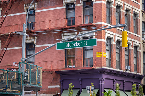 Broadway - Bleecker Street, Manhattan, New York, USA - August 23th 2023:  Corner of a residential brownstone house and signs with street names