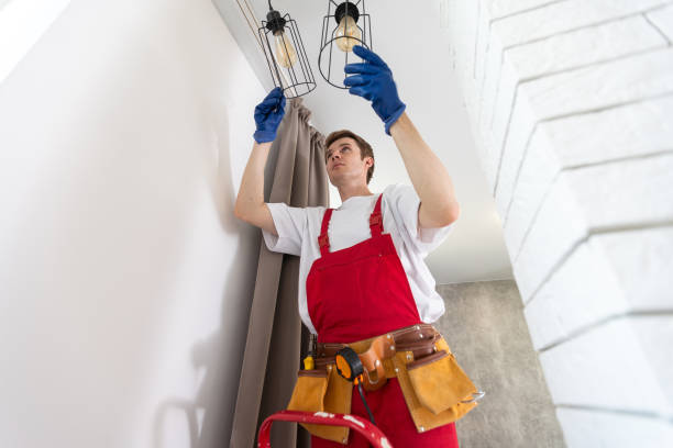 elektriker bei der arbeit. service für die reparatur von elektrischen verkabelungen und austausch von deckenlampen. ein bauherr installiert eine dachbodendecke. rent-a-gent hilft bei der hausarbeit - einbauspots stock-fotos und bilder