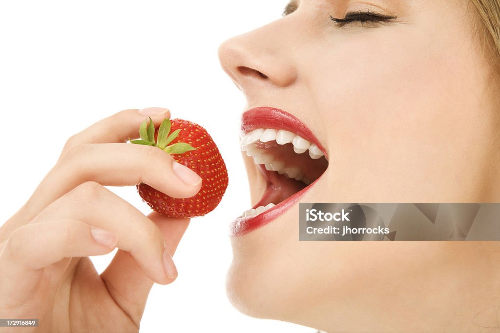 Jeune femme manger une délicieuse fraise - Photo de 16-17 ans libre de droits