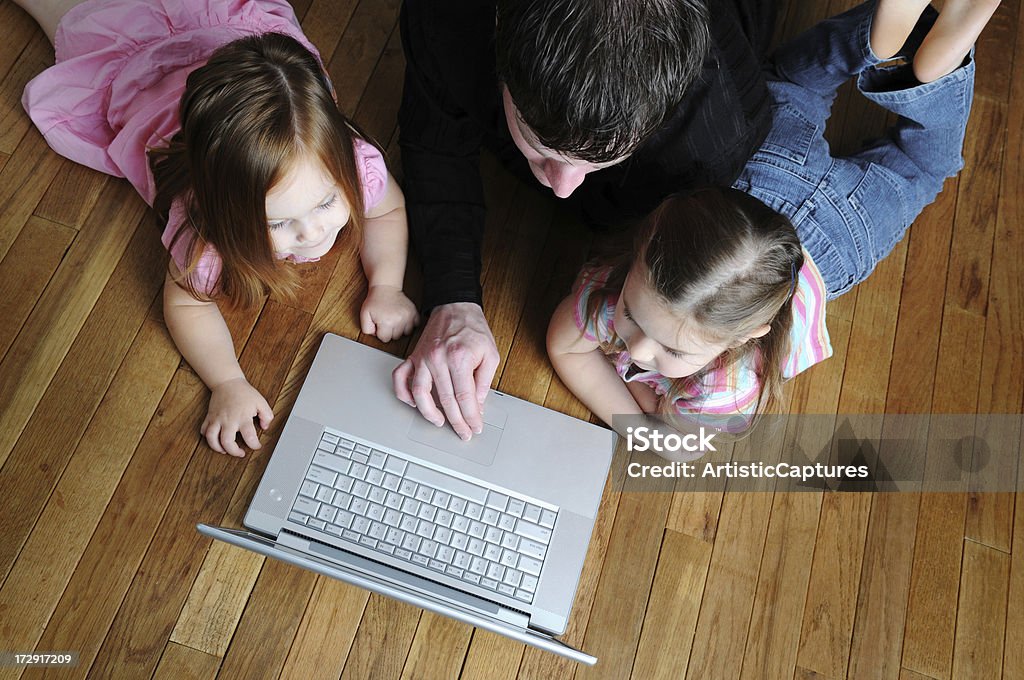 Family Computer Time A father and his two daughters with a laptop computer. 2-3 Years Stock Photo