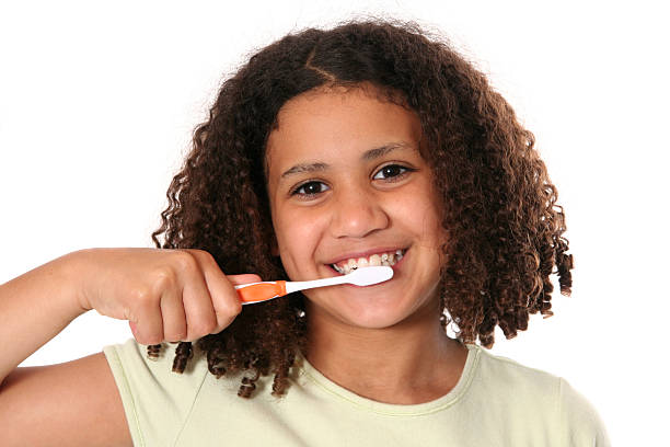 istock Smiling girl with curly hair brushing teeth 172918164