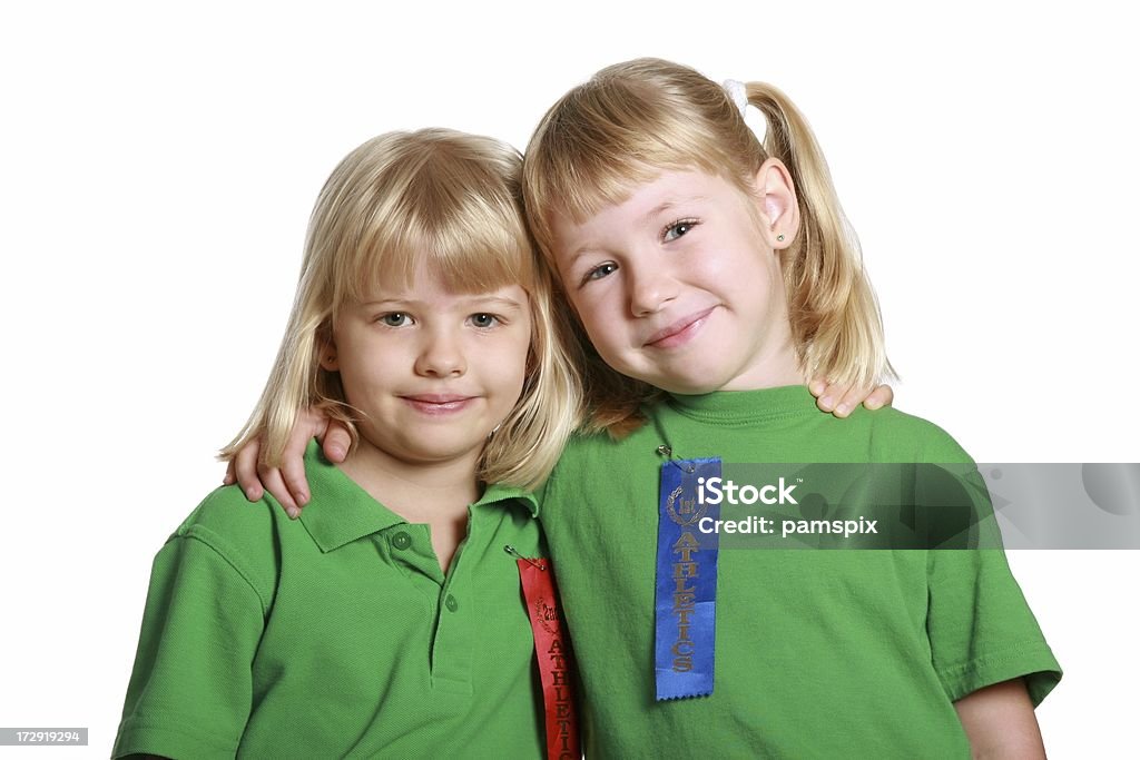 Dos niñas felices con camisas de cintas de atletismo de deportes - Foto de stock de 4-5 años libre de derechos