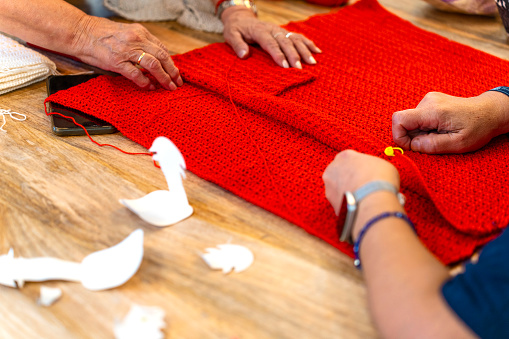 Crochet club. Close-up of an elderly woman's hands knitting.