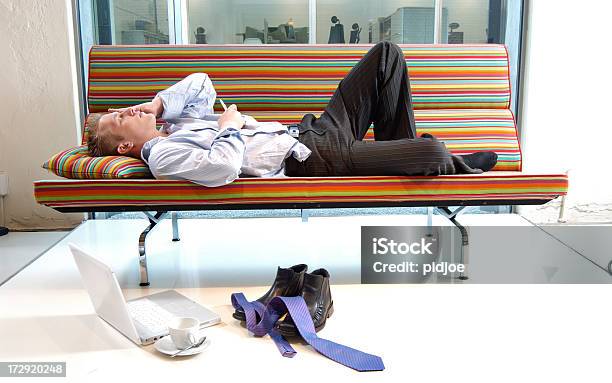 Tired Businessman Lying On Multi Colored Sofa Stock Photo - Download Image Now - Adult, Adults Only, Business