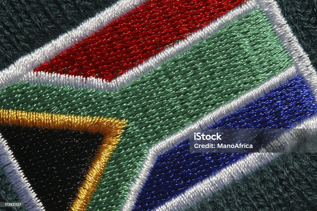 Embroidered South African flag A macro photograph of an embroidered South African flag on a dark green background. Cotton Stock Photo