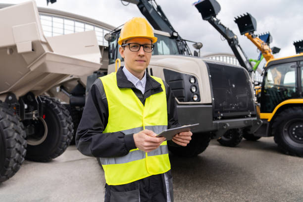 istock Man worker with tablet computer stands next to mining truck. 1729216553