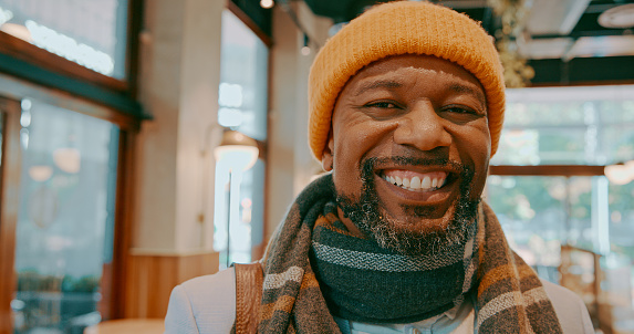 Smile, portrait and a black man at a coffee shop in the morning for a drink, breakfast or eating. Happy, mature and an African person at a cafe, restaurant or cafeteria in winter for service