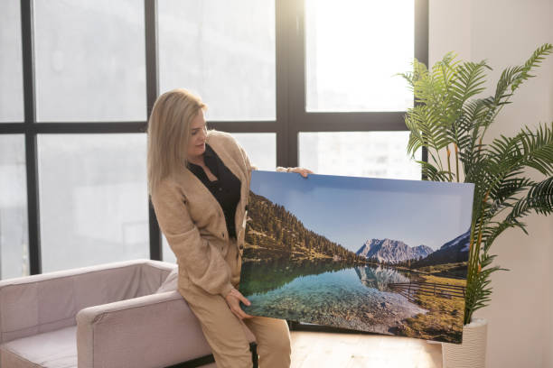 istock Girl hanging a photo canvas on a wall 1729218705