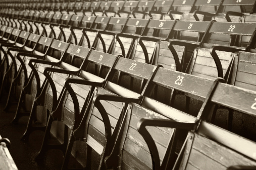 Old Time stadium seats in gray scale with a sepia tone. Shallow DOF focal point is the number \