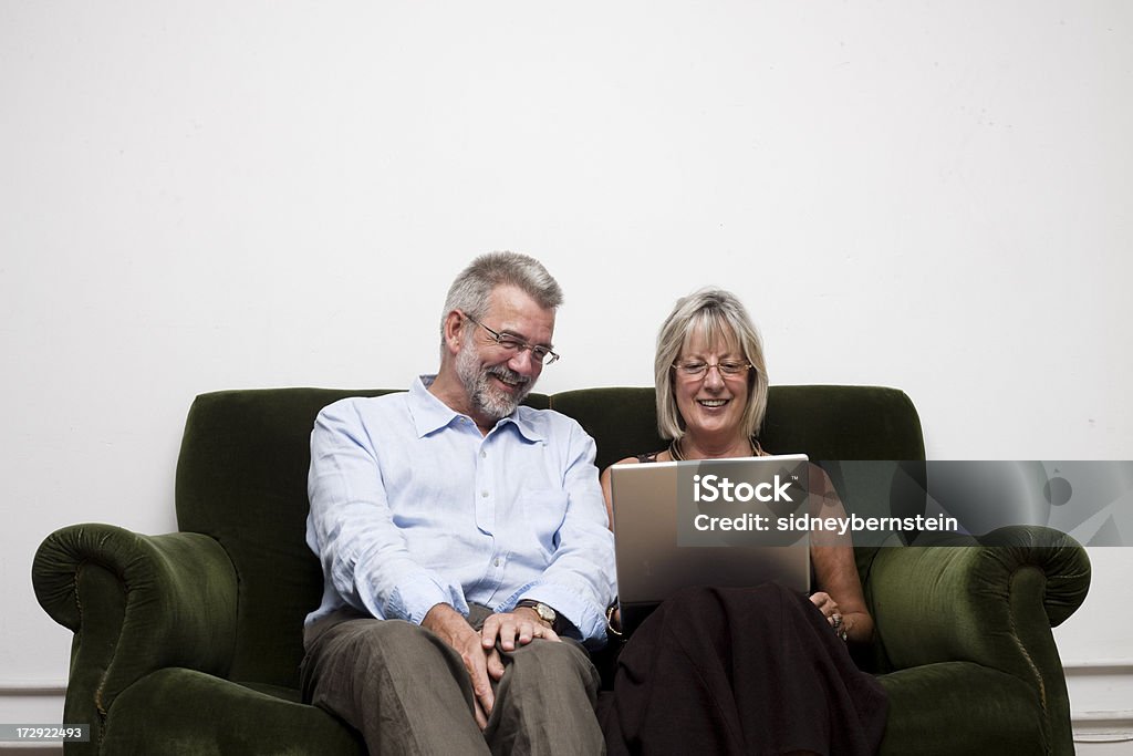 Parents with Laptop Happy mum and dad using laptop on sofa Active Seniors Stock Photo