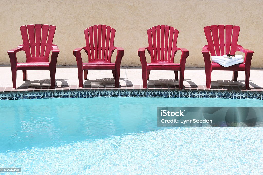 Poolside Four adirondack chairs wait for guests next to a pool. Adirondack Chair Stock Photo